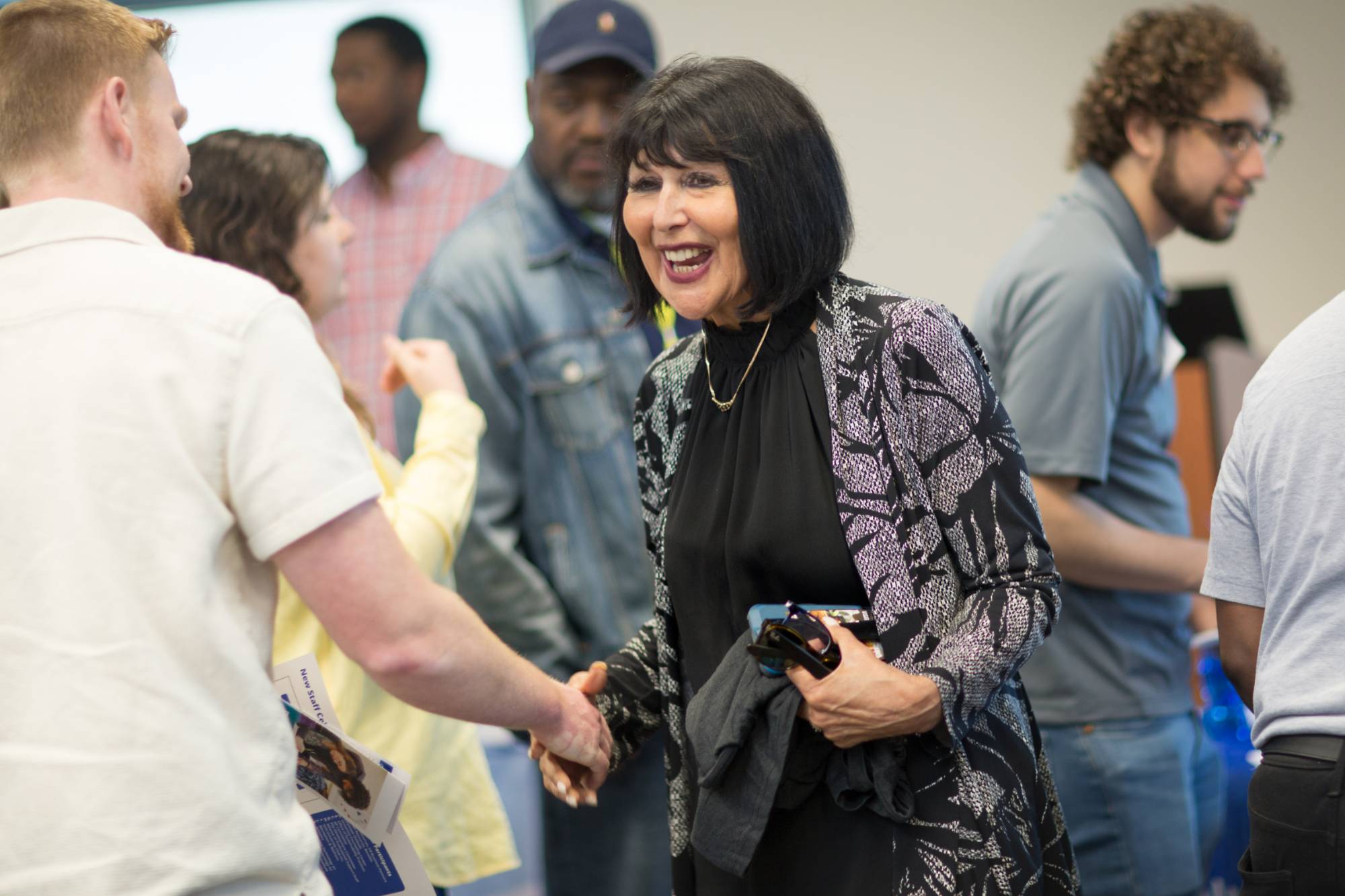 Woman smiling and shaking someone's hand